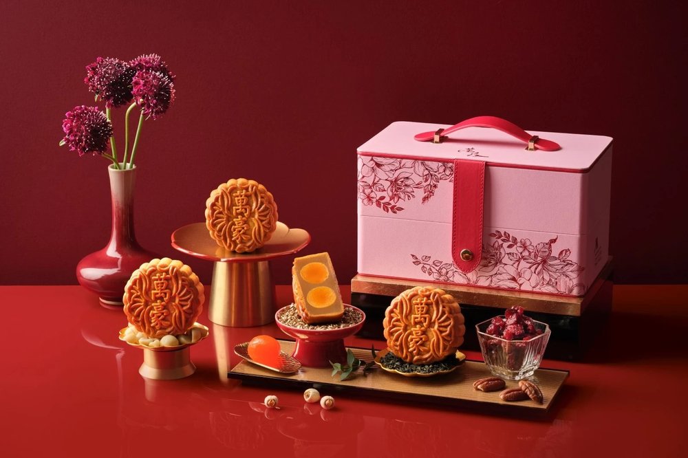 traditional baked mooncakes with maroon background and pink gift box