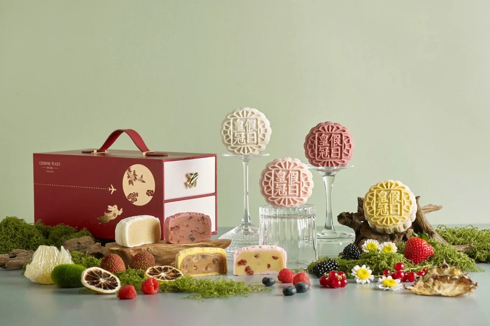 colourful snowskin mooncakes against sage green background with fruits and gift box