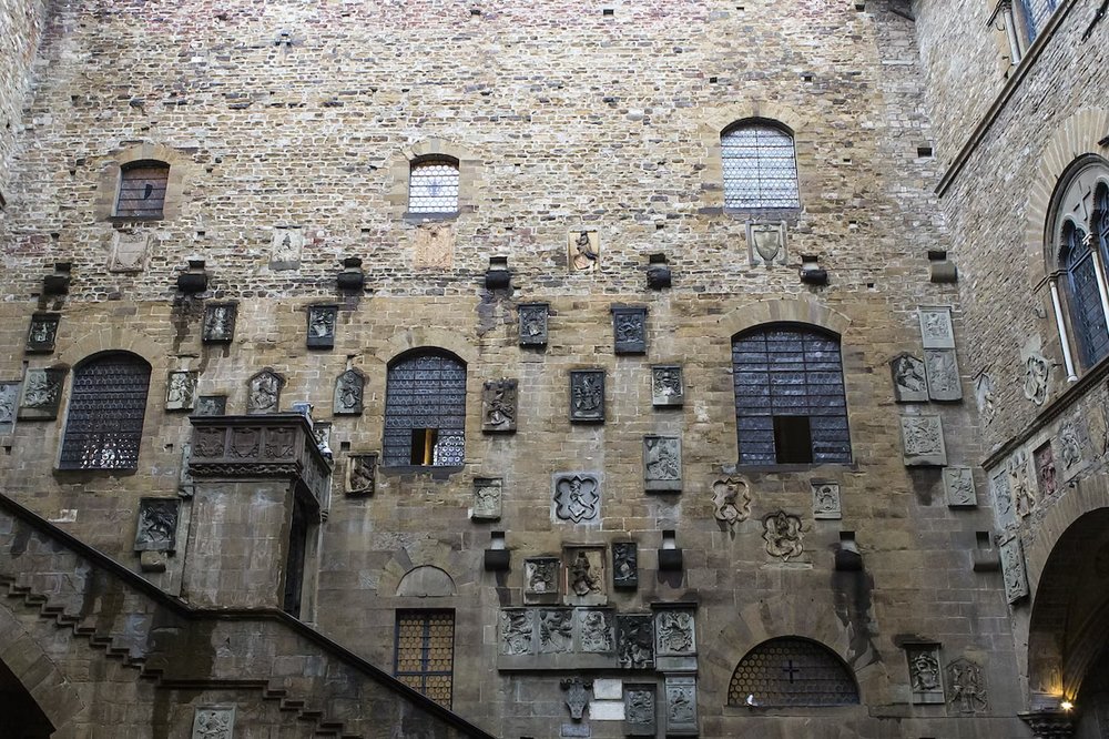 Stone carvings and windows inside the courtyard of Bargello Museum