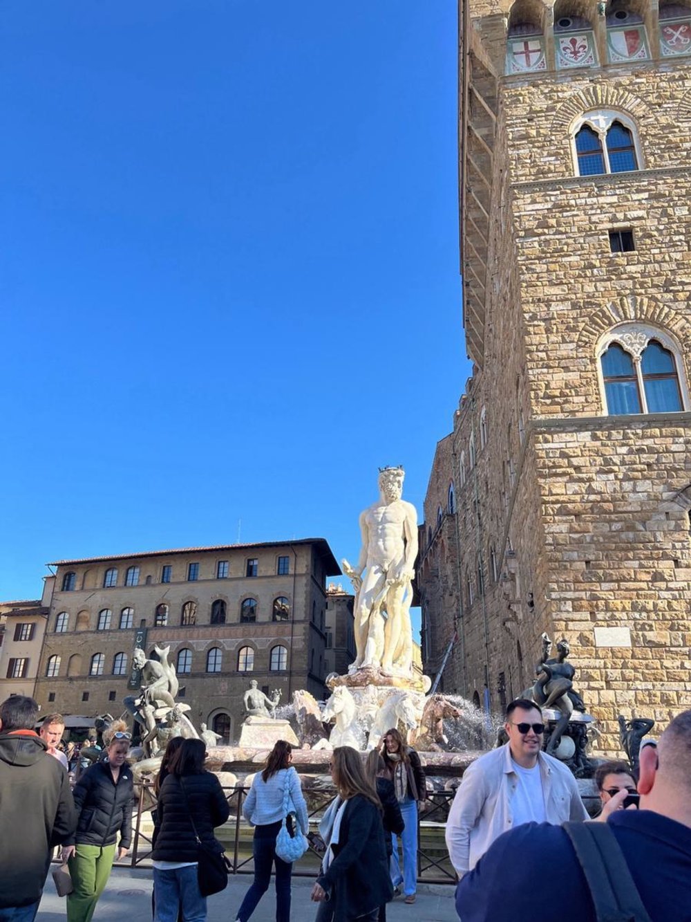 Tourists in Piazza della Signoria near Palazzo Vecchio and Neptune Fountain