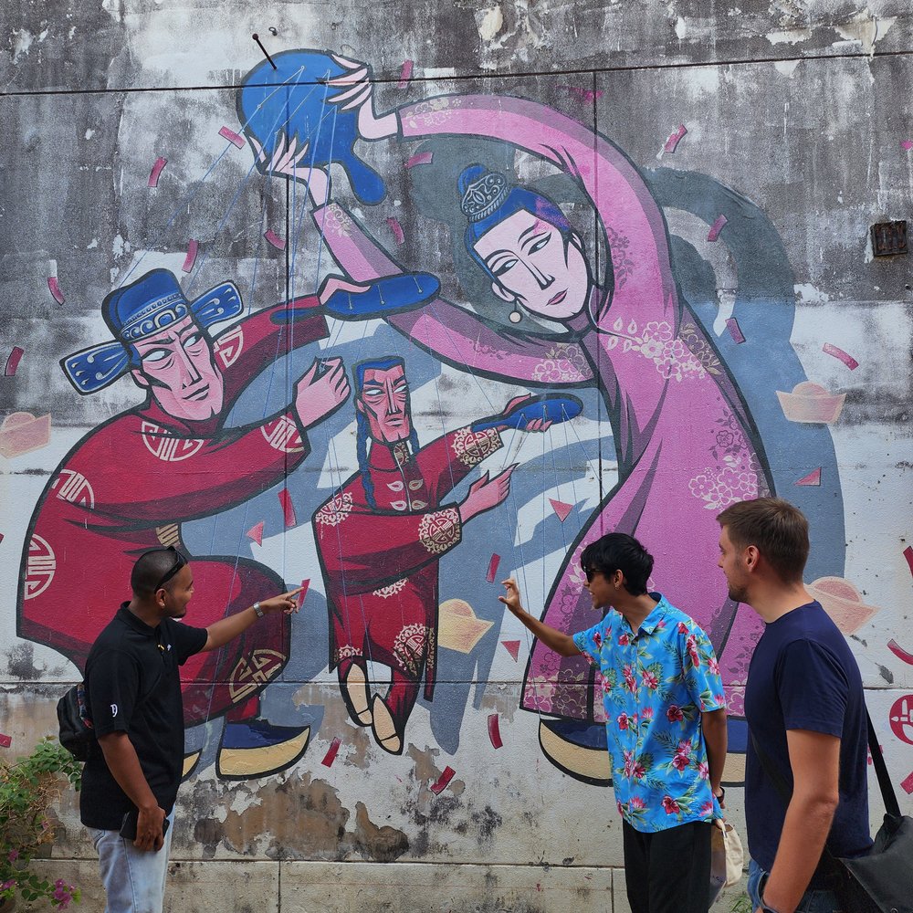 people checking out the mural in phuket old town