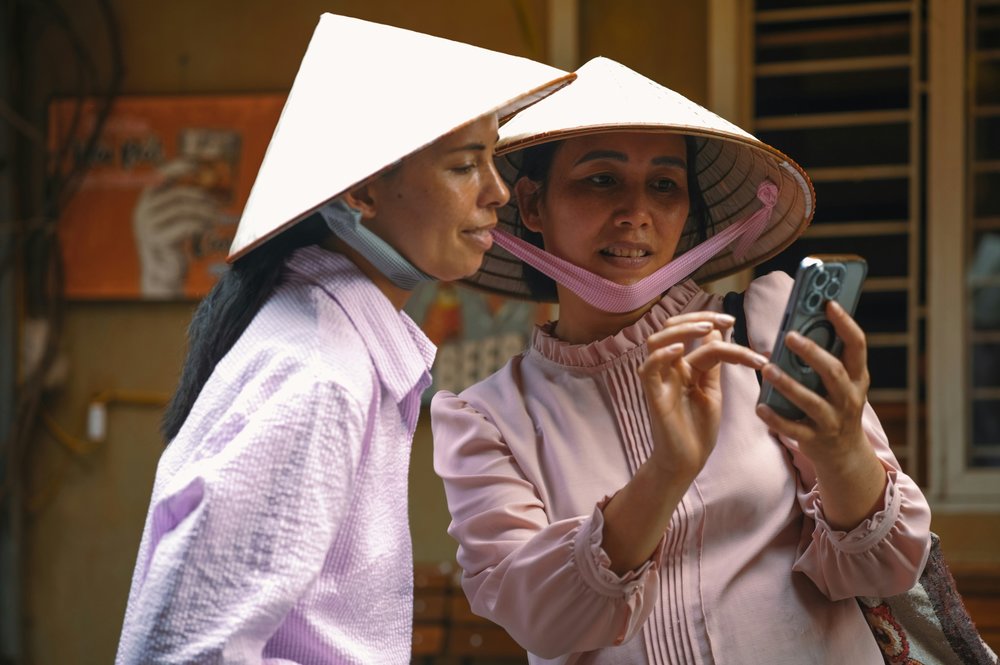 two Vietnamese people looking at a phone 