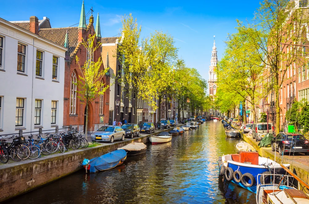 Colorful Amsterdam canal with boats, bicycles, and historic houses