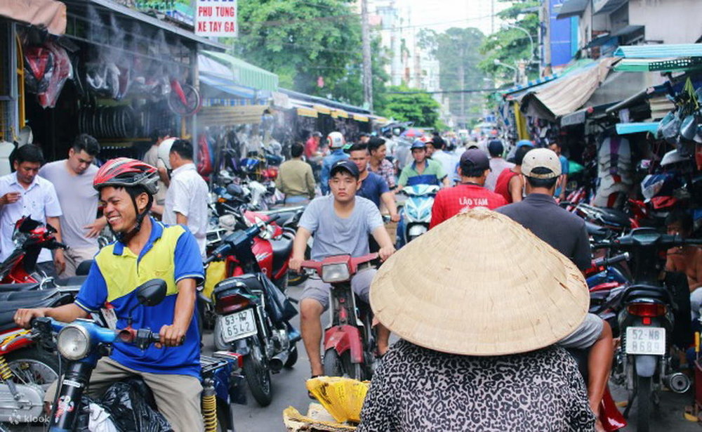 Motorbikes rides through the market streets