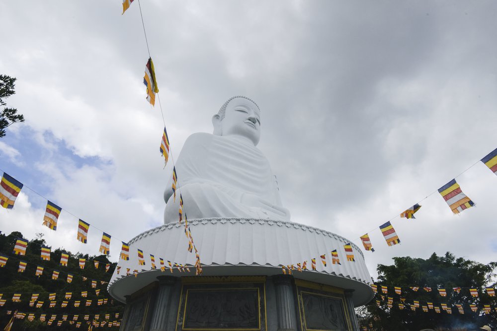 White Giant Buddha statue surrounded by prayer flags at Ba Na Hills Vietnam