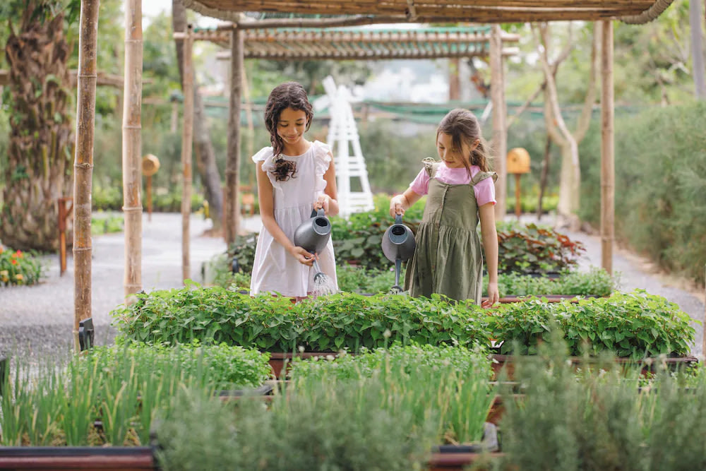Kids watering the plants at Camp Hyatt Kids’ Club