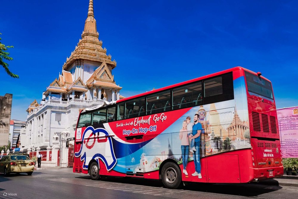 The Hop-on and Hop-off bus passing by a Thai temple