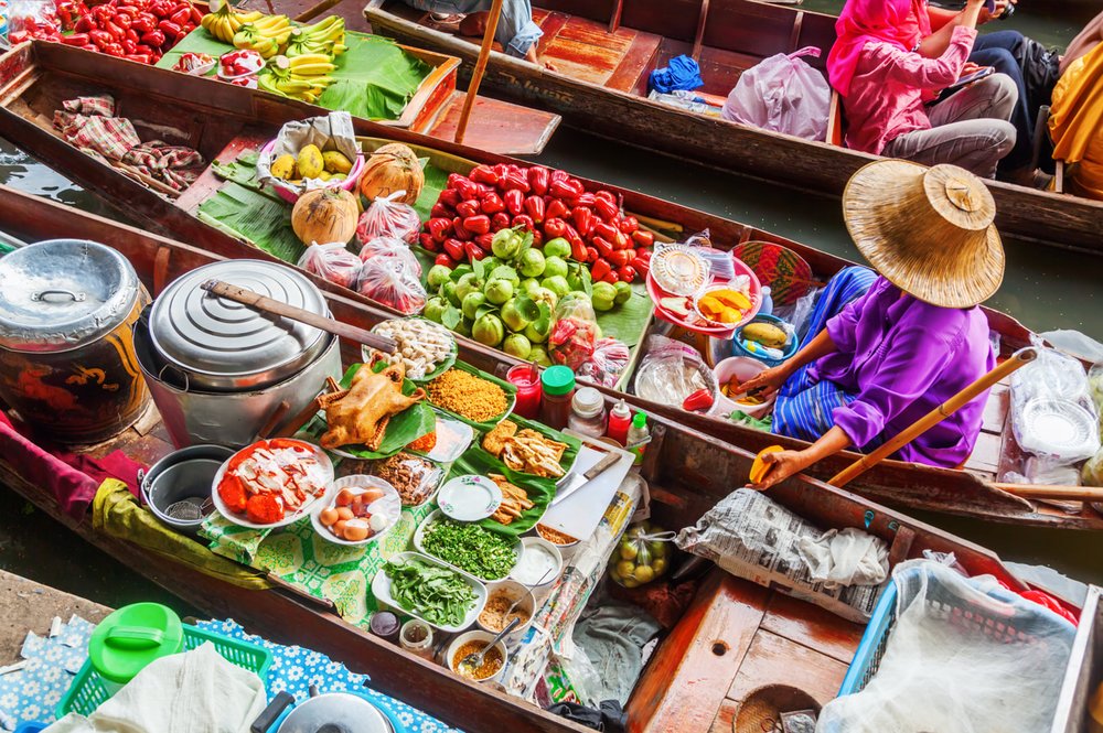 A vendor on a boat selling fresh produce