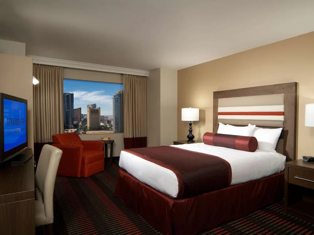 Guest room at The STRAT Hotel Las Vegas with large window and city view