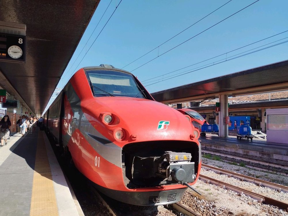 Frecciarossa high-speed train at the platform with travelers getting on