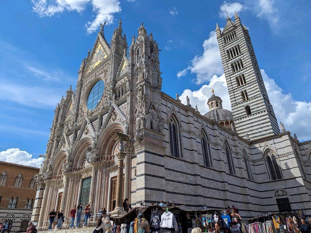 Siena Cathedral with striped marble design and crowds outside the entrance