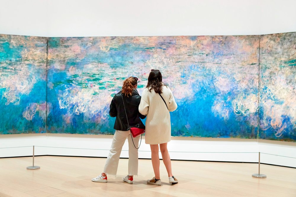 Two individuals looking at an art in the Museum of Modern Art