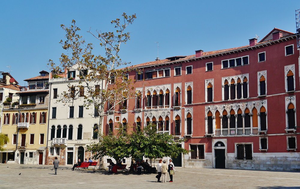 San Polo square with historic buildings and people relaxing in Venice