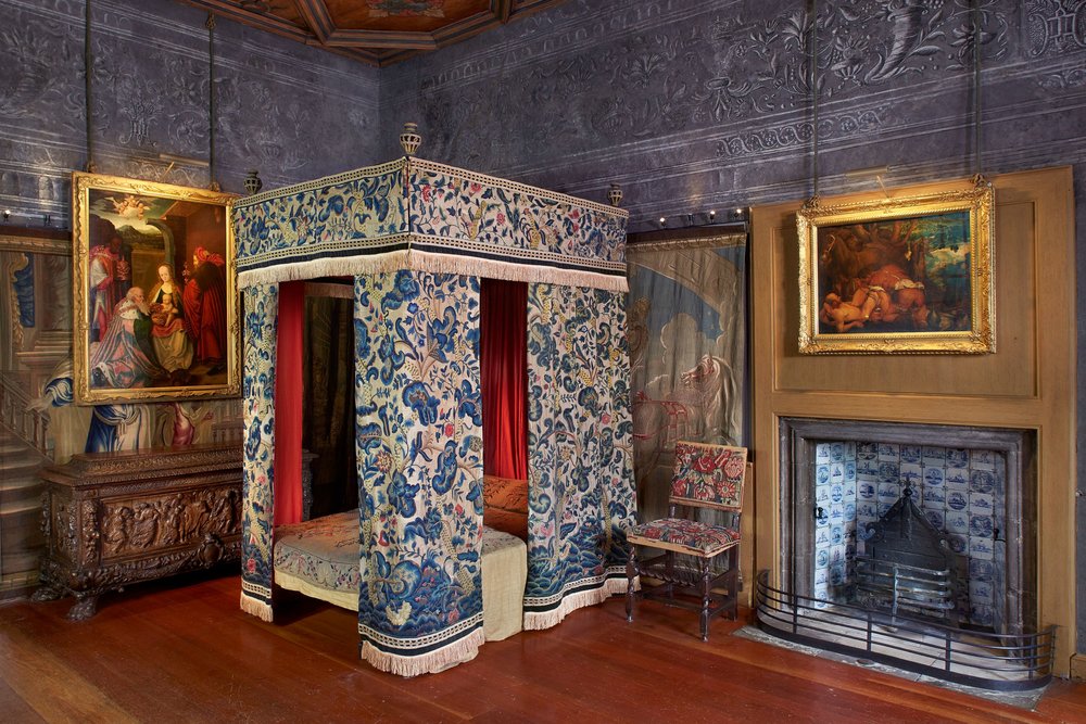 Mary Queen of Scots' bedchamber with ornate canopy bed and historic tapestries