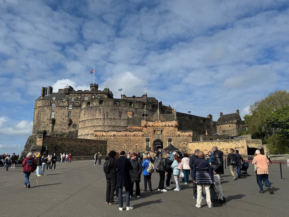 Tourists outside the entrance of Edinburgh Castle under blue skies