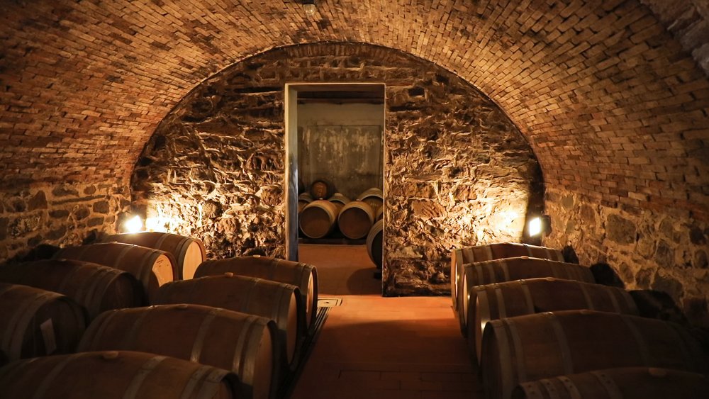 Stone wine cellar in Tuscany filled with wooden barrels for aging Chianti wines