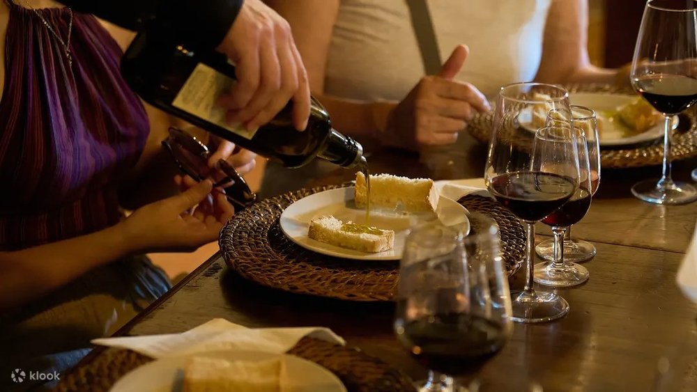 Olive oil being poured on bread during a wine and olive oil tasting experience in Tuscany