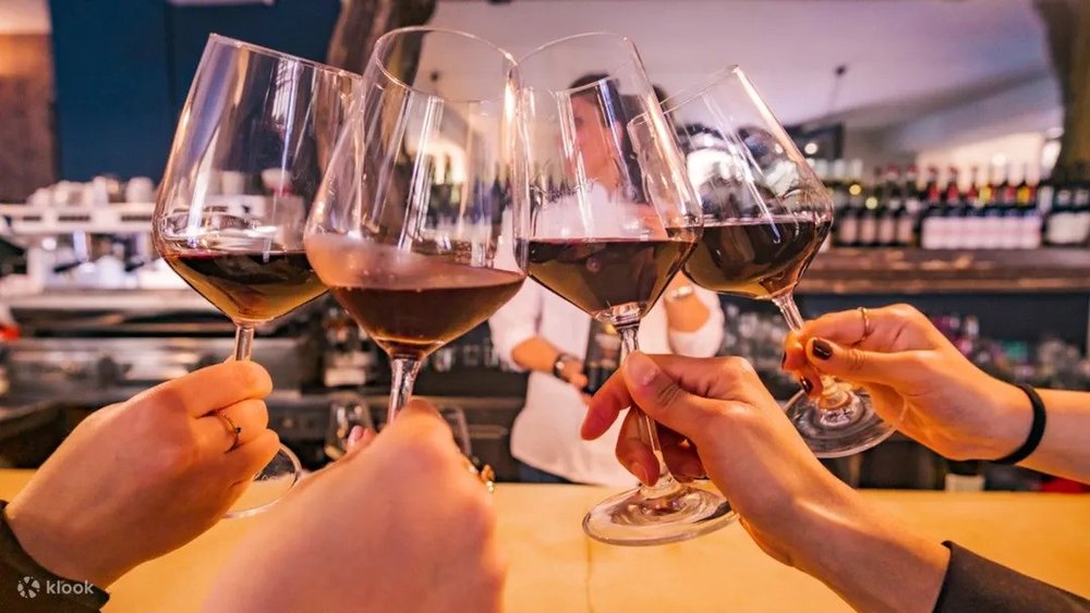 Group clinking red wine glasses in a cozy Florence wine bar