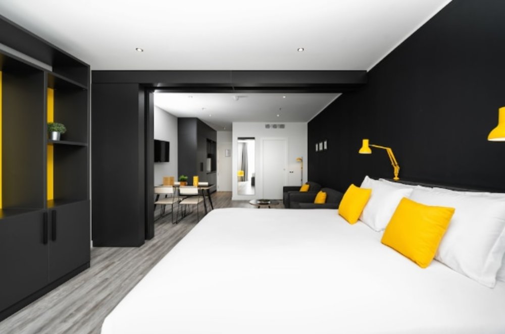 An apartment-style room, complete with a kitchenette, living room, and dining area