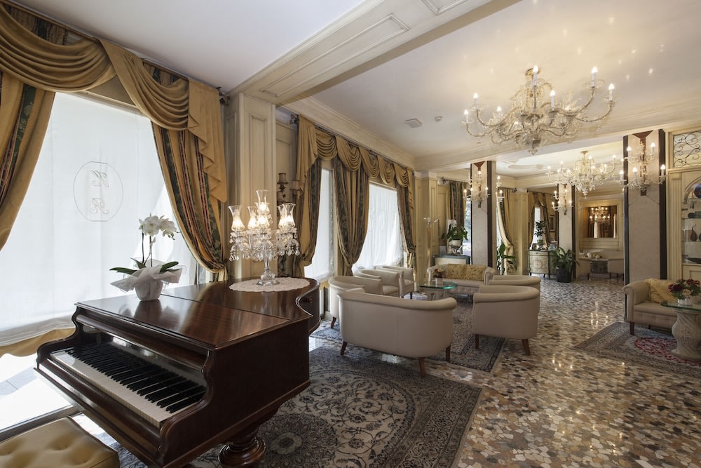 A beautiful grand piano and plush seating in the Hotel Riviera lobby