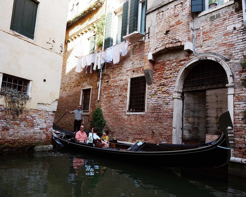 Gondola ride through quiet back canals of Venice with historic architecture