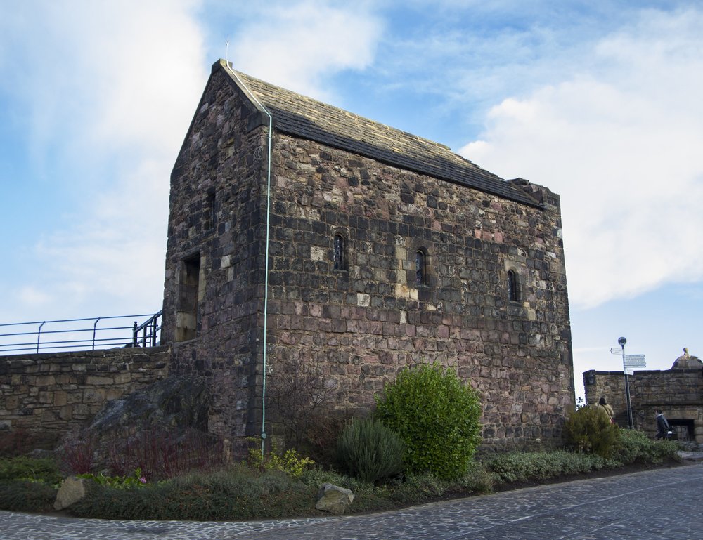 Exterior of St. Margaret’s Chapel at Edinburgh Castle under a blue sky