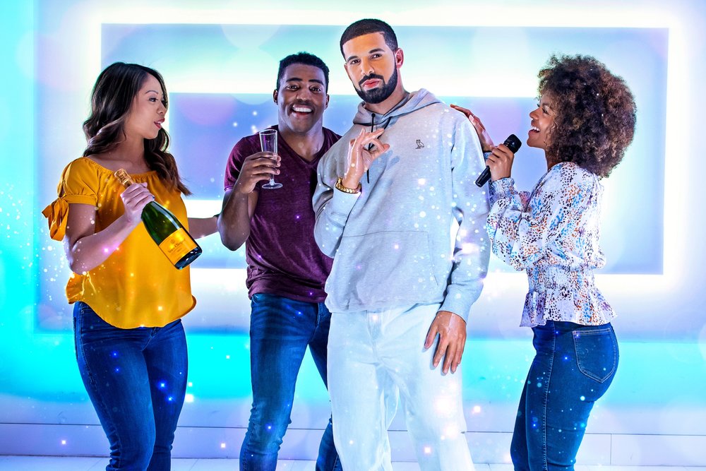 People posing for a photo with Drake’s wax figure