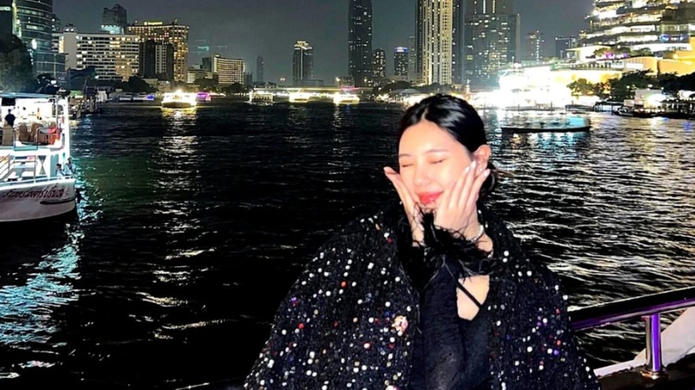 woman posing for a picture in front of the chao phraya river, bangkok