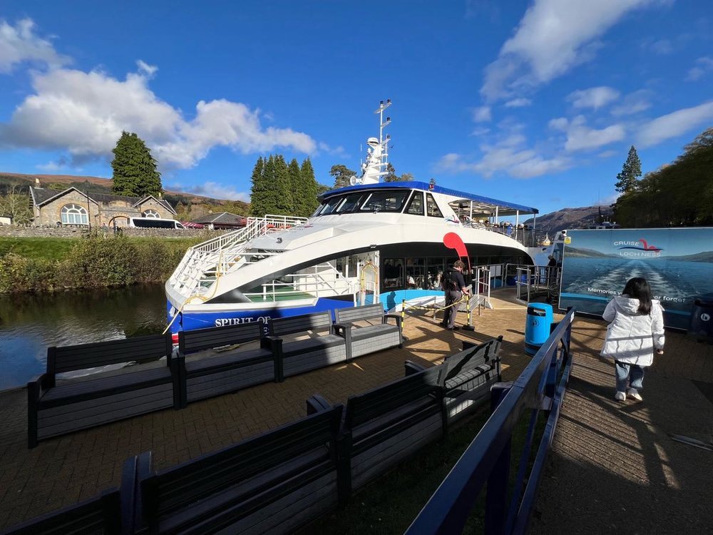 Loch Ness cruise boat docked with blue skies at Fort Augustus departure point.