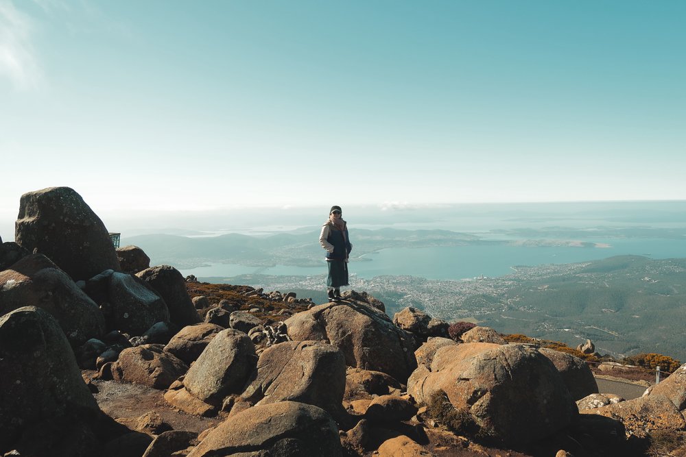 girl on rocks overlooking Mount Wellington–Hobart