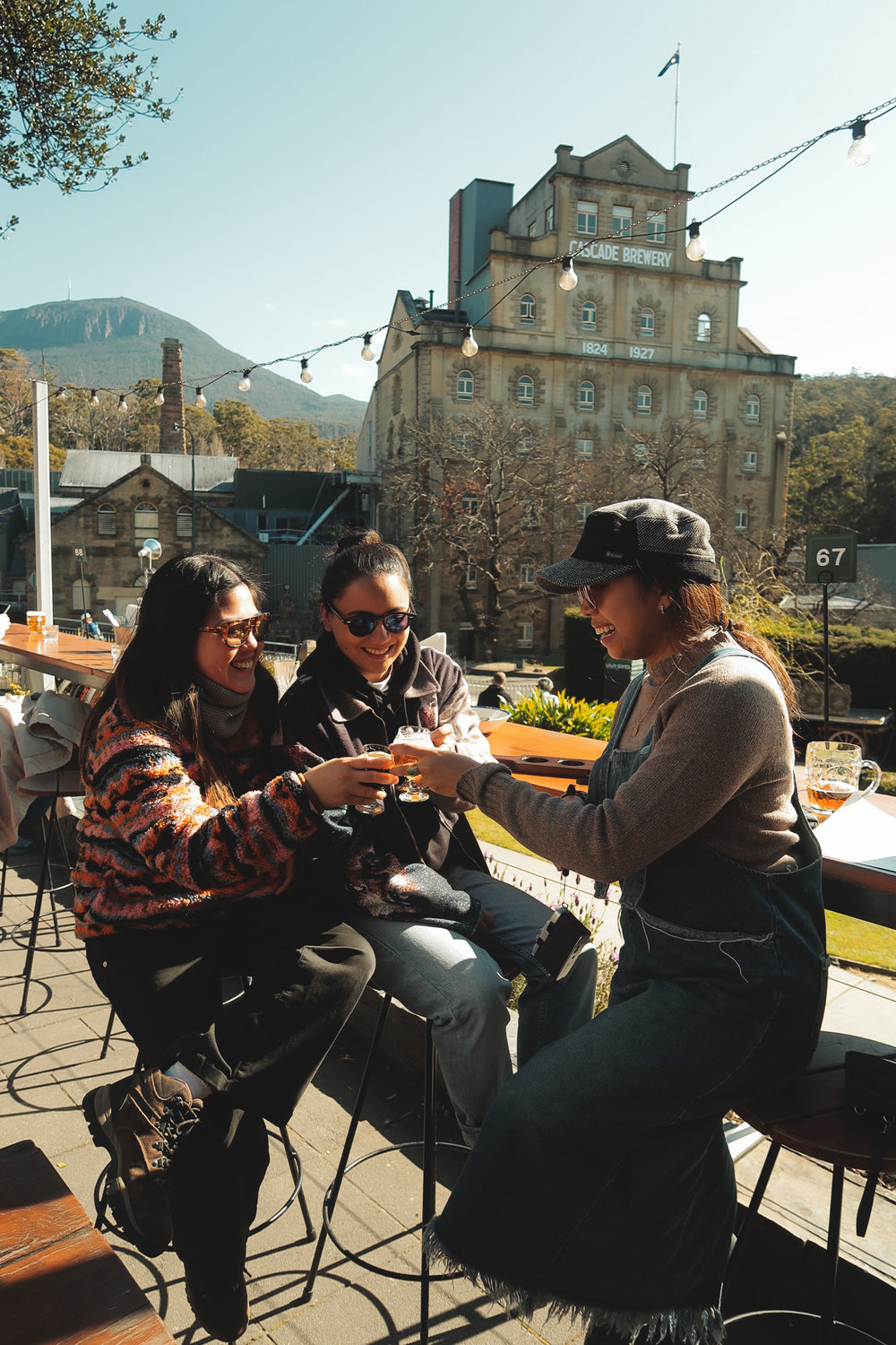 three women clinking glasses of beer at Cascade Brewery Hobart