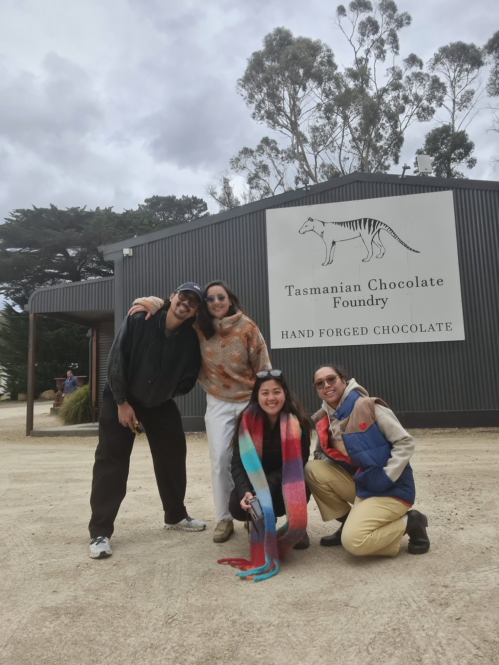 four friends taking a photo in front of Tasmanian Chocolate Factory