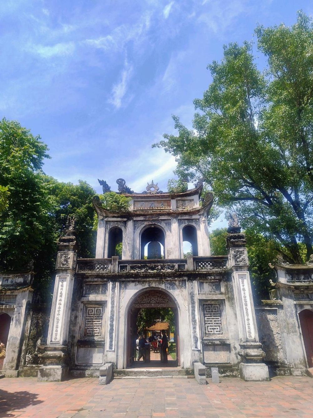 Ancient stone gate at Temple of Literature with blue sky in Hanoi Vietnam