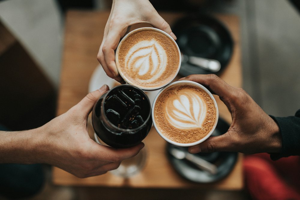 Friends holding a cup of coffee in a cafe
