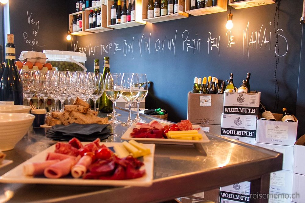 Wine glasses and plates of charcuterie and cheese sprawled on a table