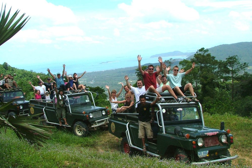 Groups of people onboard an army jeep in a tropical jungle