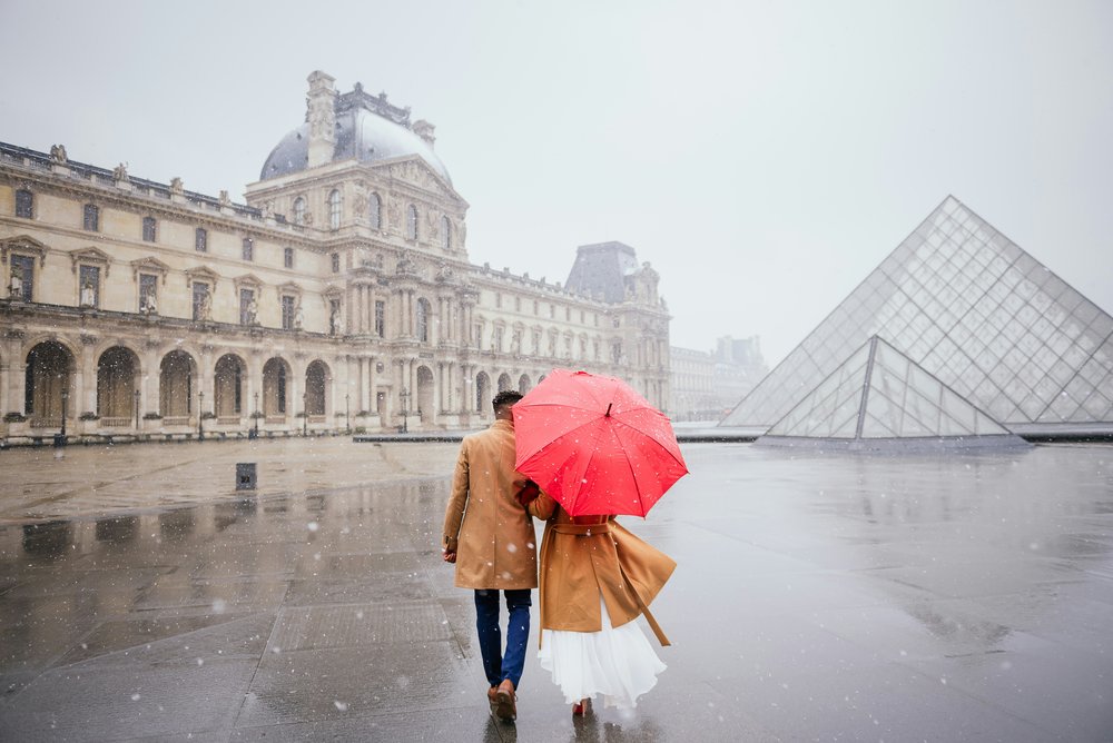 A couple walking by the Louvre
