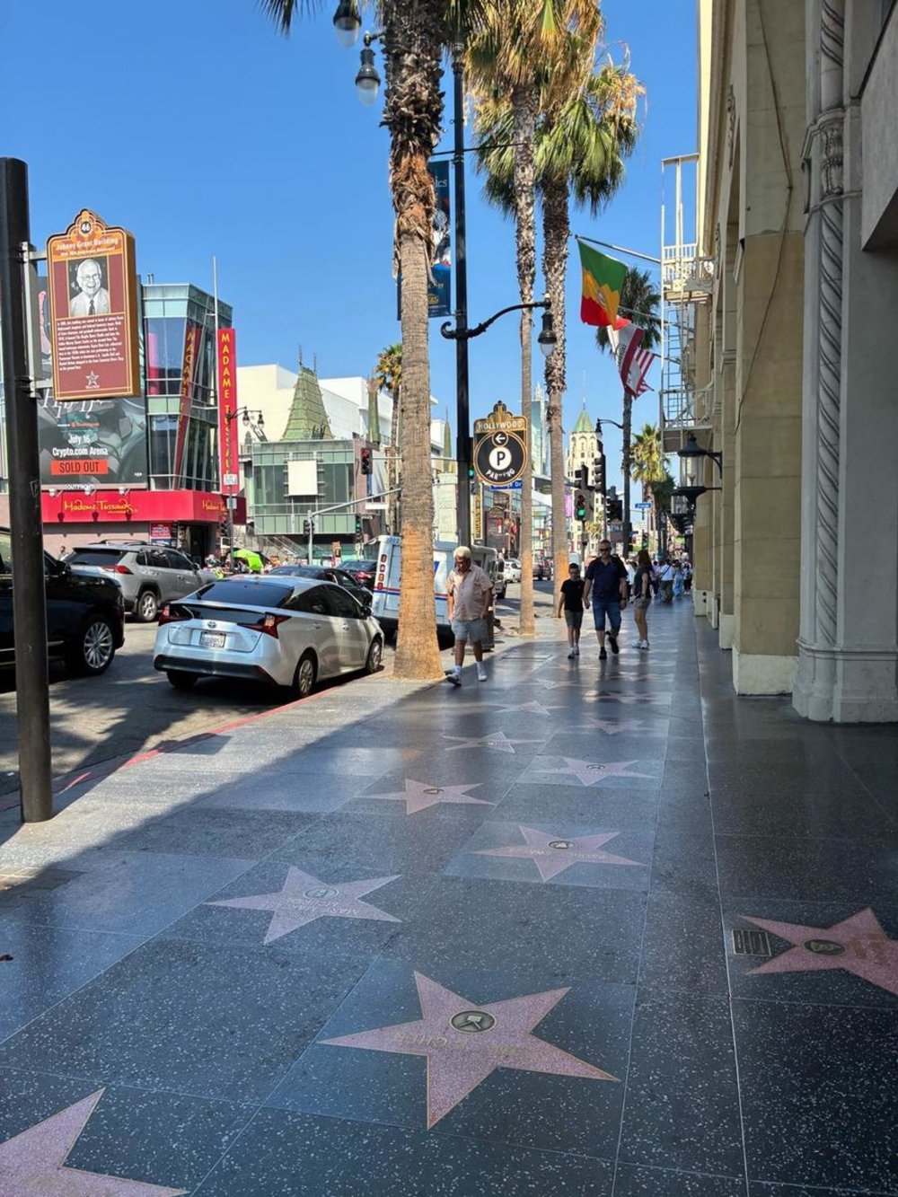 Tourists walking beside stars on the Hollywood Walk of Fame in Los Angeles
