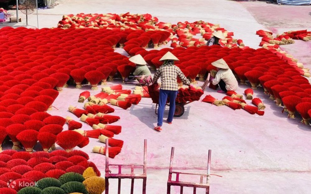 Workers in traditional conical hats in the Red Incense Village