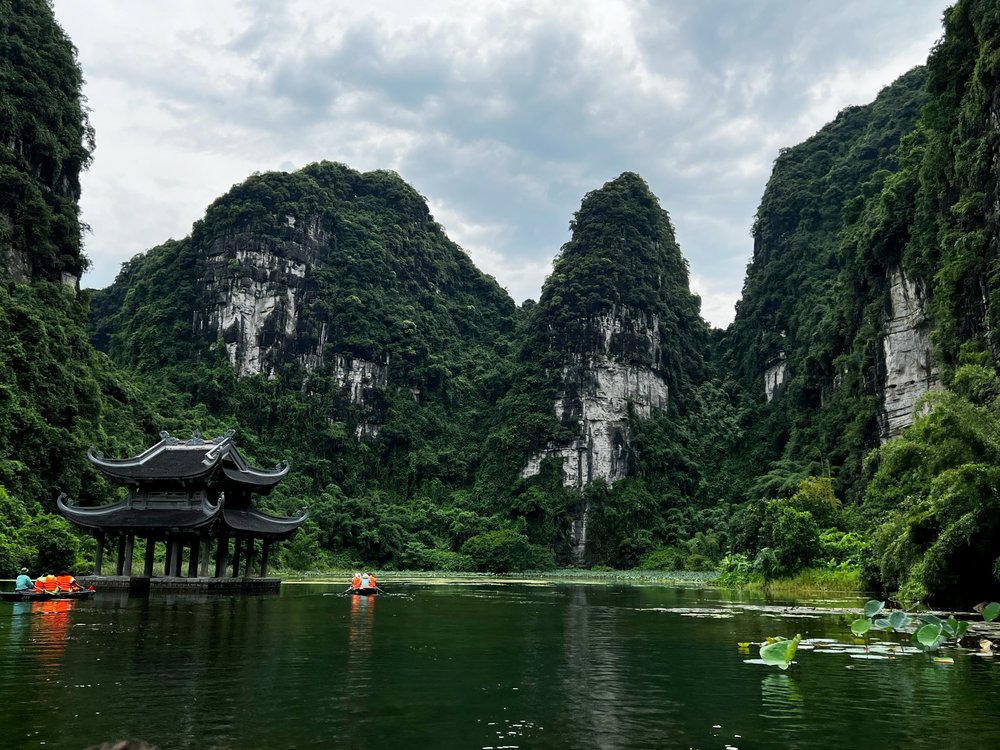 Ninh Binh river and limestone mountains with boats and pagoda