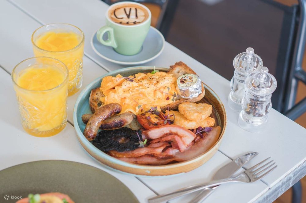 Plate of typical Australian breakfast with eggs, sausages, and hash