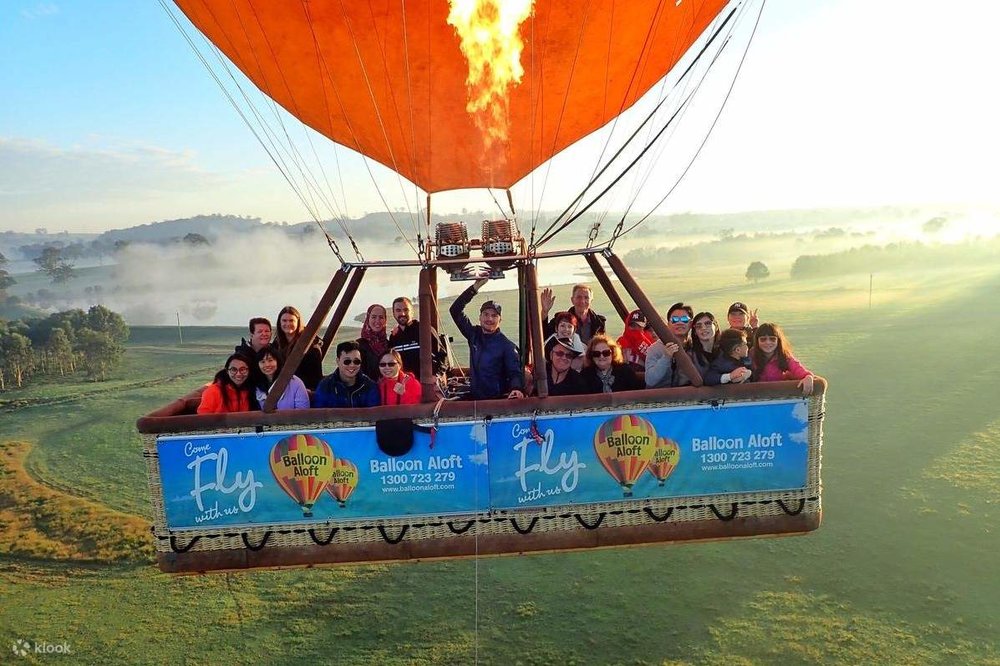 Passengers of a hot air balloon flying over Camden Valley in New South Wales, Australia