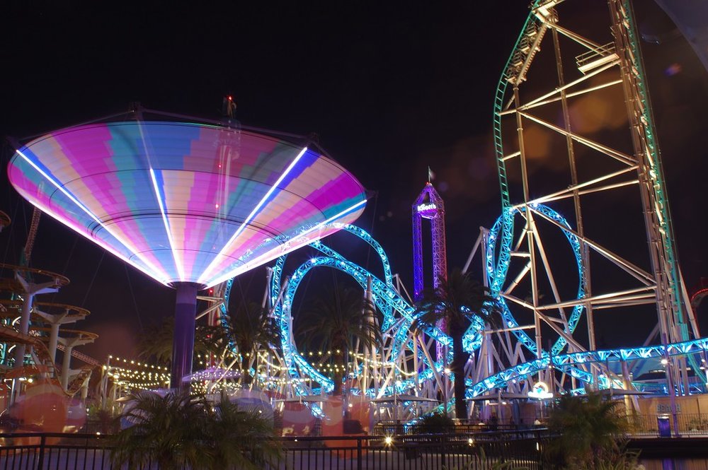 Night view of illuminated rides and roller coasters at Knott’s Berry Farm.