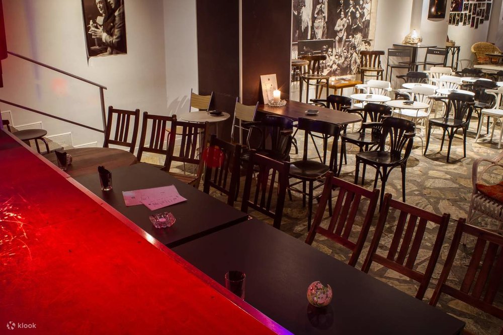 Tables and chairs are placed directly below the stage, while the rest of the venue is filled with chairs.