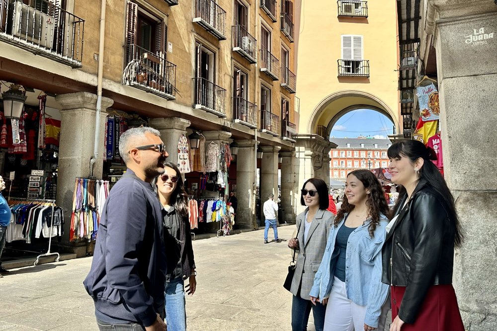 Visitors by an archway leading to the Plaza Mayor of Madrid