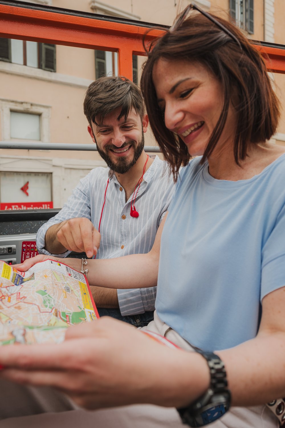 Couple looking at a hop on hop off Rome map on the bus