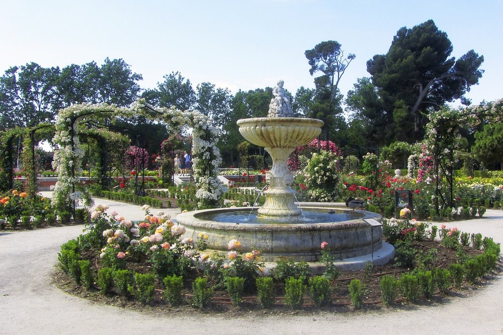 Flower-filled rose garden and fountain in Retiro Park