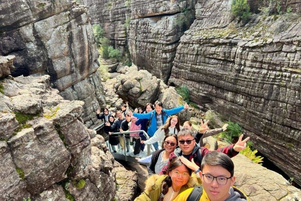 A group of tourists taking a photo with the Grand Canyon as their backdrop