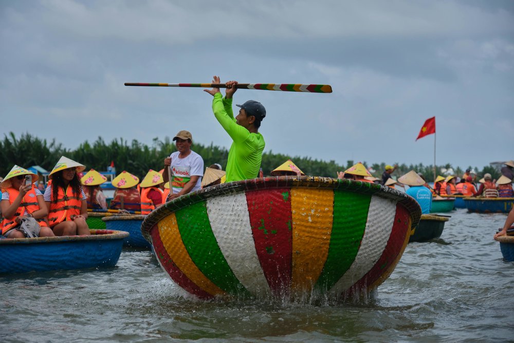 Local residents in Cam Thanh Coconut Village performing inside a bamboo basket.