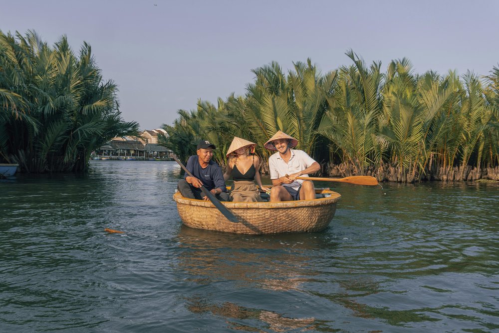Travelers in a coconut basket boat surrounded by lush nipa palms